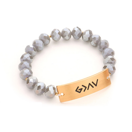 An image of a religious bracelet with faceted beads, featuring the empowering message "God is greater than the highs and lows".