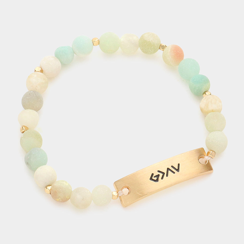 A meaningful bracelet with a metal bar and natural stone beads, highlighting the phrase "God is Greater Than the Highs and Lows."