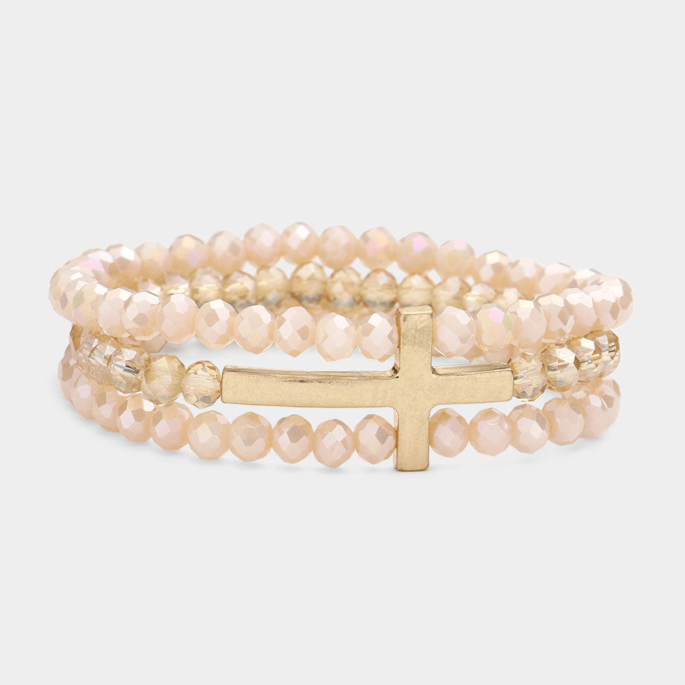 Neutral toned faceted beaded bracelet with a striking metal cross feature